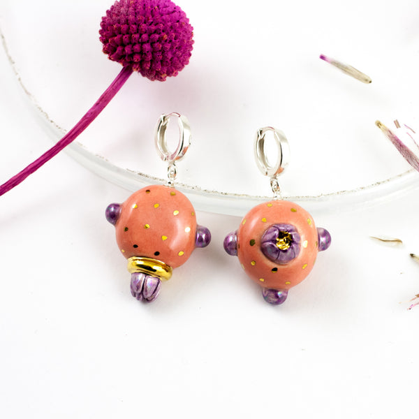 Purpuriniai ir rožiniai kabantys gėlių auskarai su aukso ir perlų blizgesiu