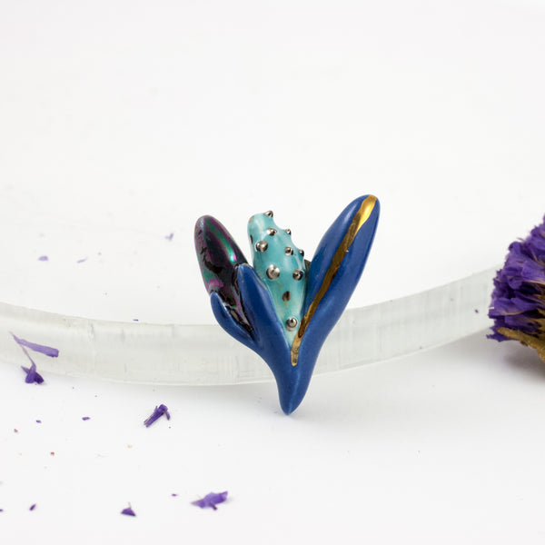 Mėlynos spalvos gėlių sagė su platinos ir aukso blizgesiu