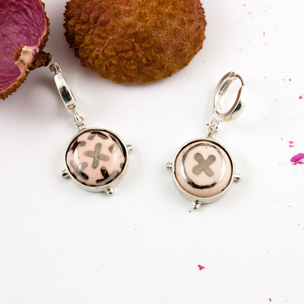 Šviesiai rausvi kabantys auskarai su platinos ornamentais