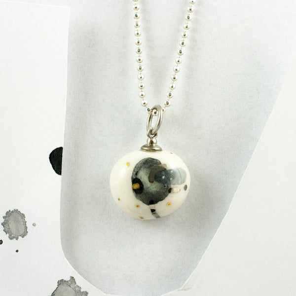 Neliels ovāls keramikas kulons ar grafisku ABSTRACT zīmējumu