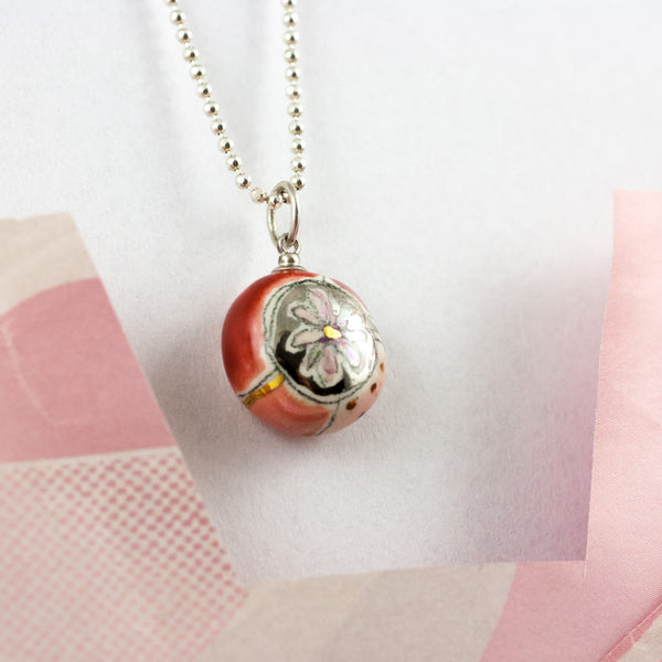 Pink ceramic pendant with a flower and platinum decor