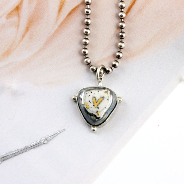 ABSTRACT grey pendant with a gold heart