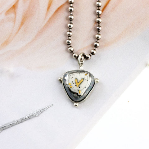 ABSTRACT grey pendant with a gold heart