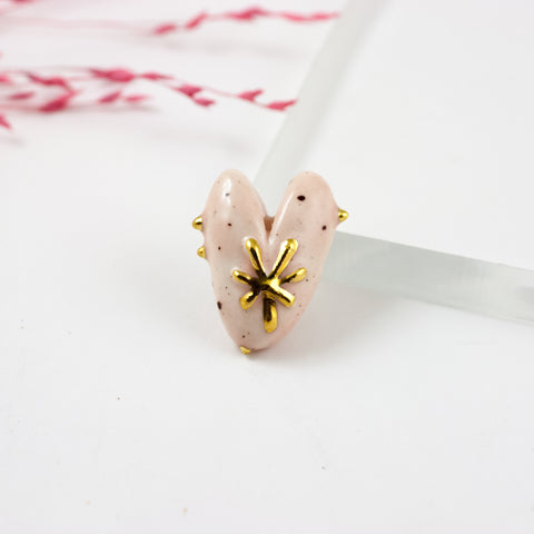 Rožinė širdelės formos sagė su aukso gėle