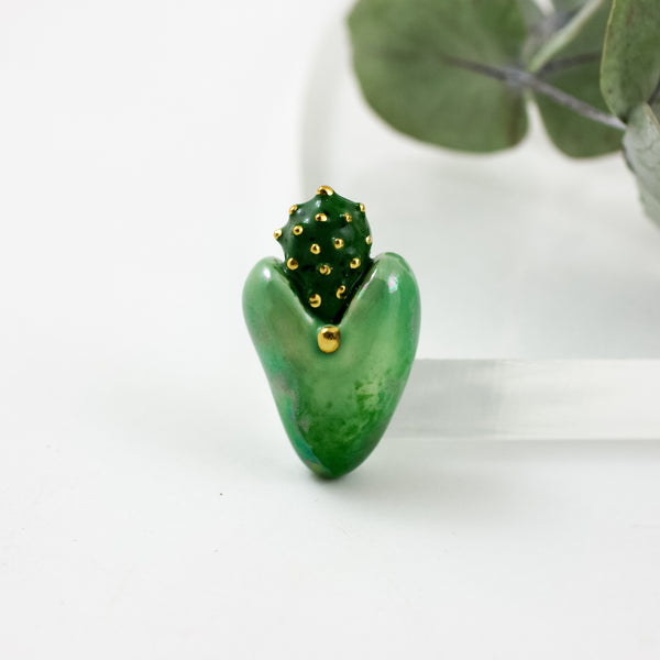 An ombre green heart-shaped brooch with gold spots