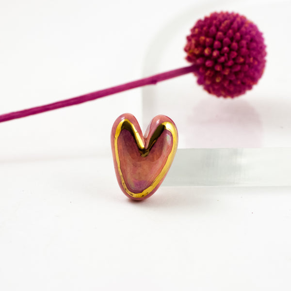 Pink heart-shaped brooch with a gold line