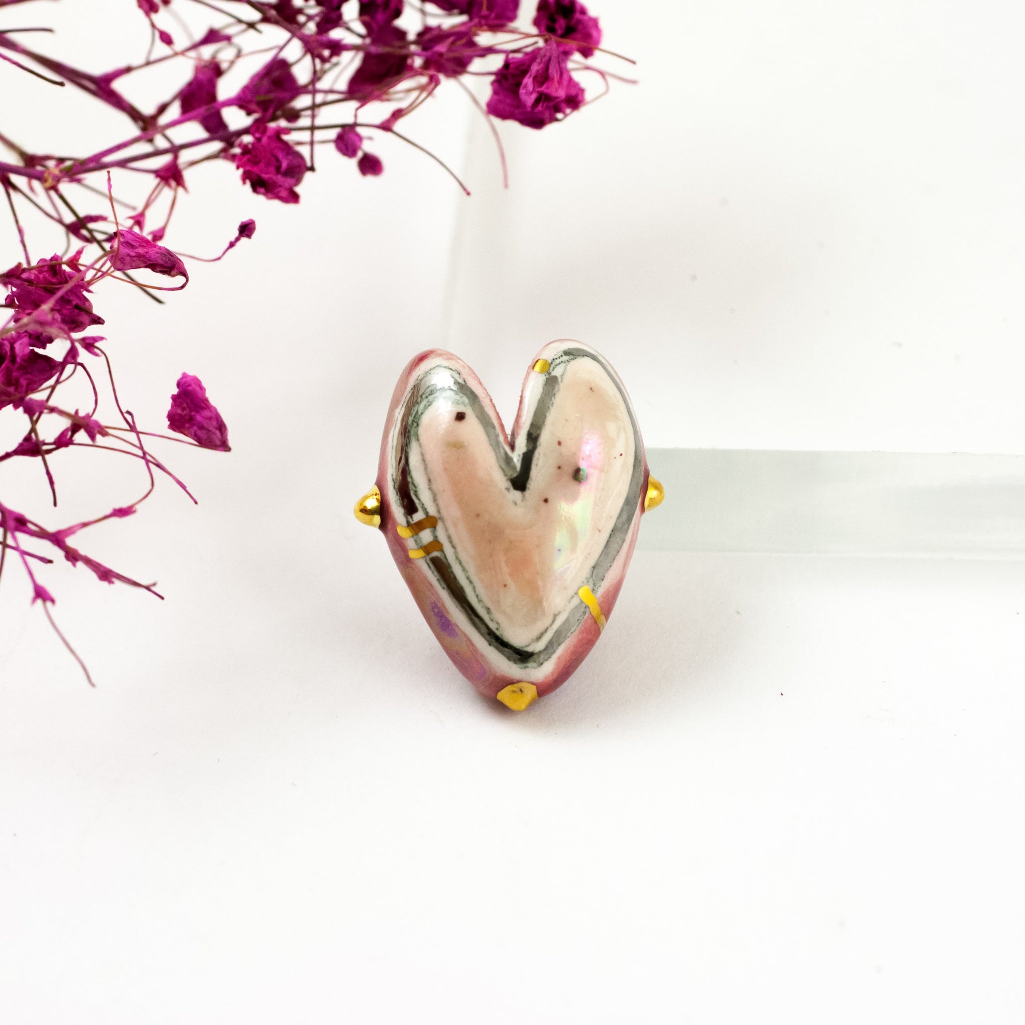 Rožinė ir raudona širdelės formos sagė su aukso ir platinos blizgesiais