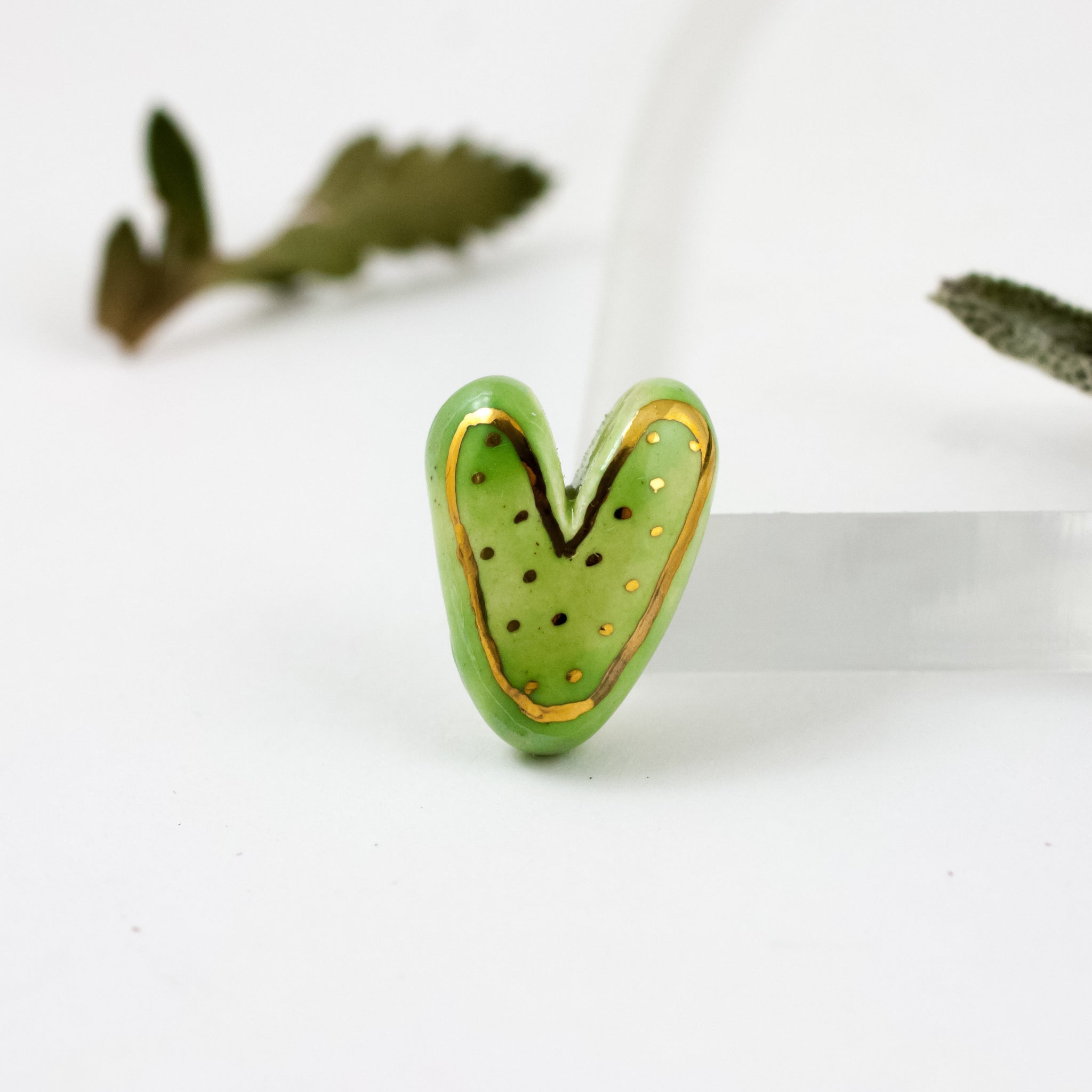 Litght green heart-shaped brooch with gold dots