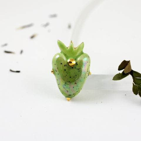 Ryškiai žalia širdelės formos sagė su aukso karūna ir taškeliais