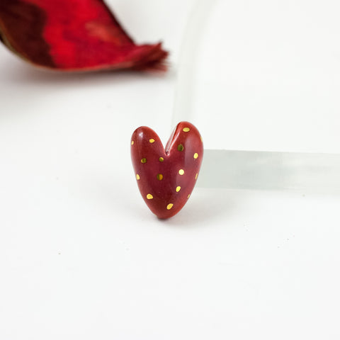 Raudona širdelės formos sagė su aukso blizgesiu