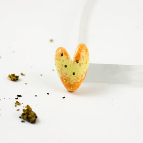 Geltona ir oranžinė širdelės formos sagė su aukso taškeliais