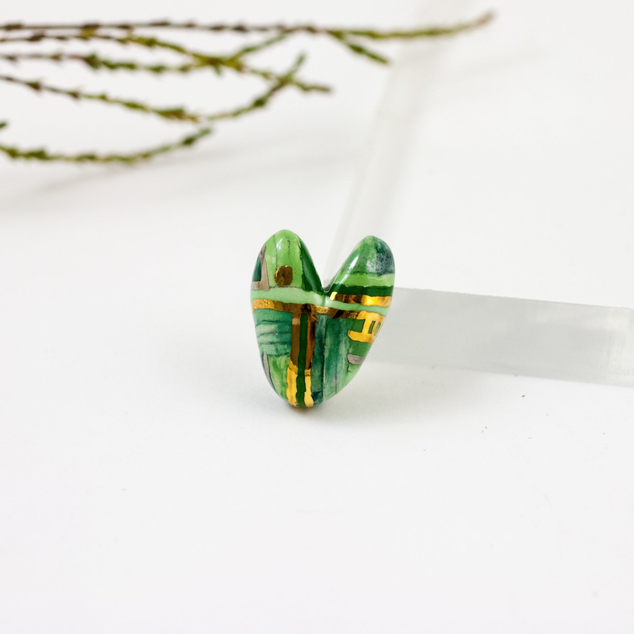 Dryžuota žalia širdelės formos sagė su liustrais