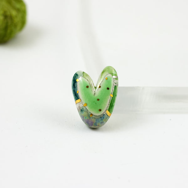 Green heart-shaped brooch with gold and platinum luster decor