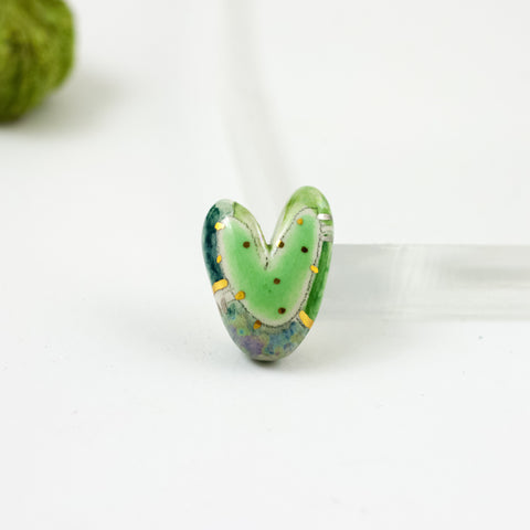 Green heart-shaped brooch with gold and platinum luster decor
