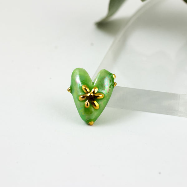 Green heart shaped brooch with a gold luster flower