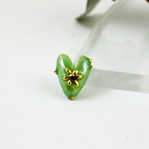 Green heart shaped brooch with a gold luster flower