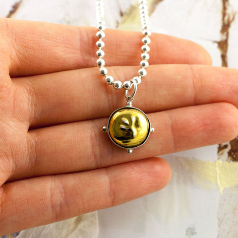 Gold color round pendant with small flower