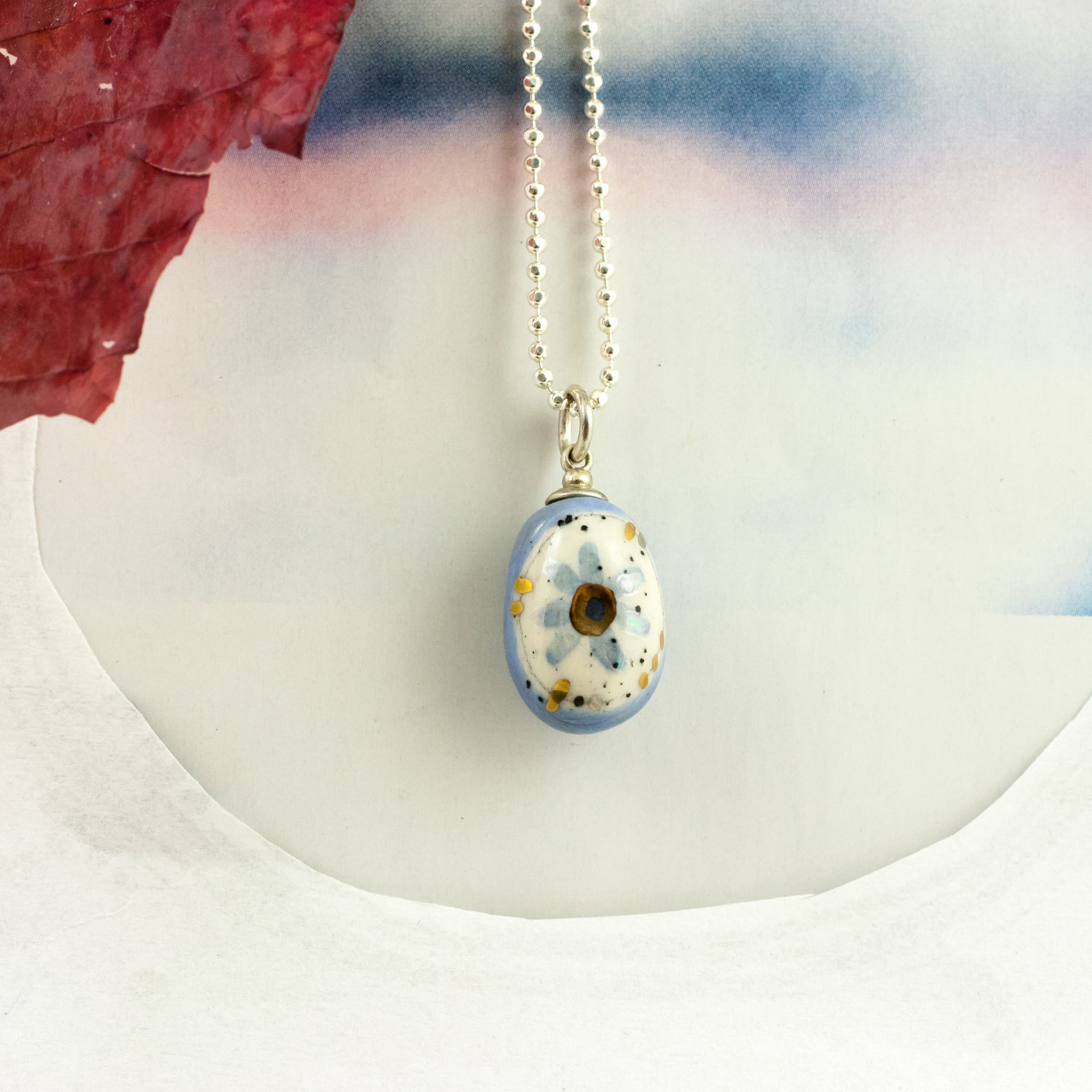 Blue oval form pendant with a flower BON BON