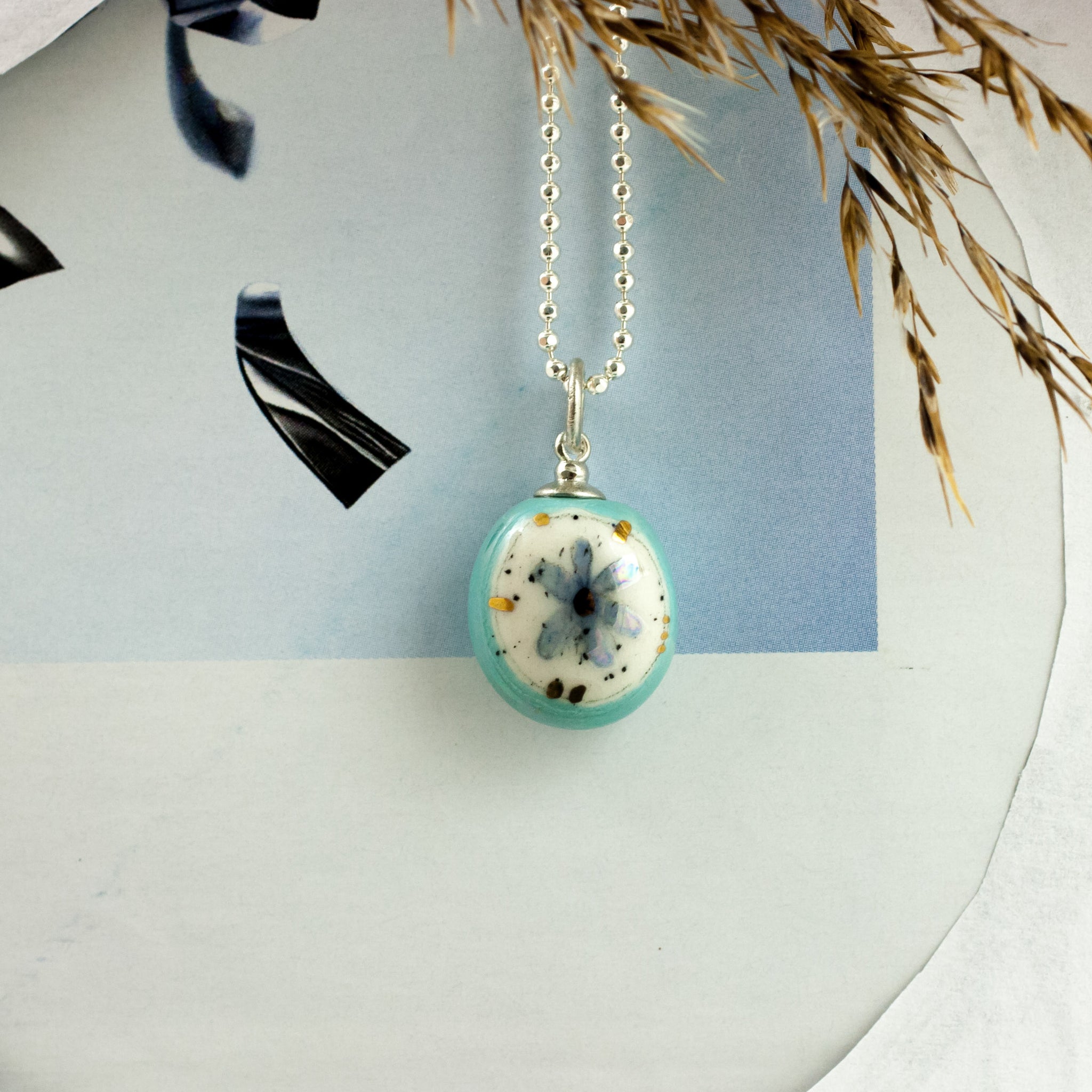 Teal oval form pendant with a flower BON BON