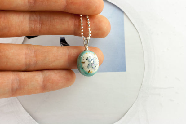 Teal oval form pendant with a flower BON BON