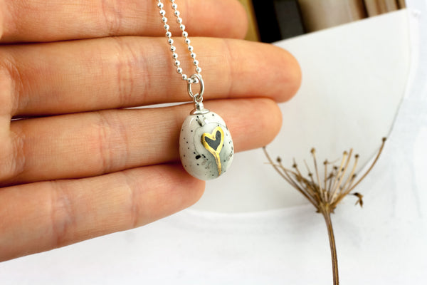 White oval form ceramic pendant with a black heart