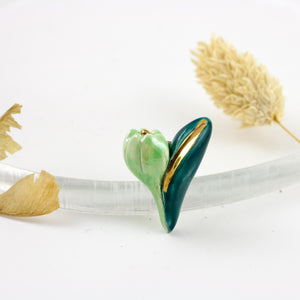 Green ceramic brooch with a golden luster line