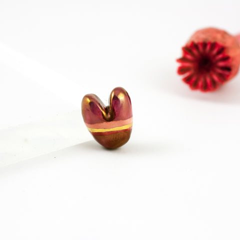 Dark red heart-shaped brooch with a gold line