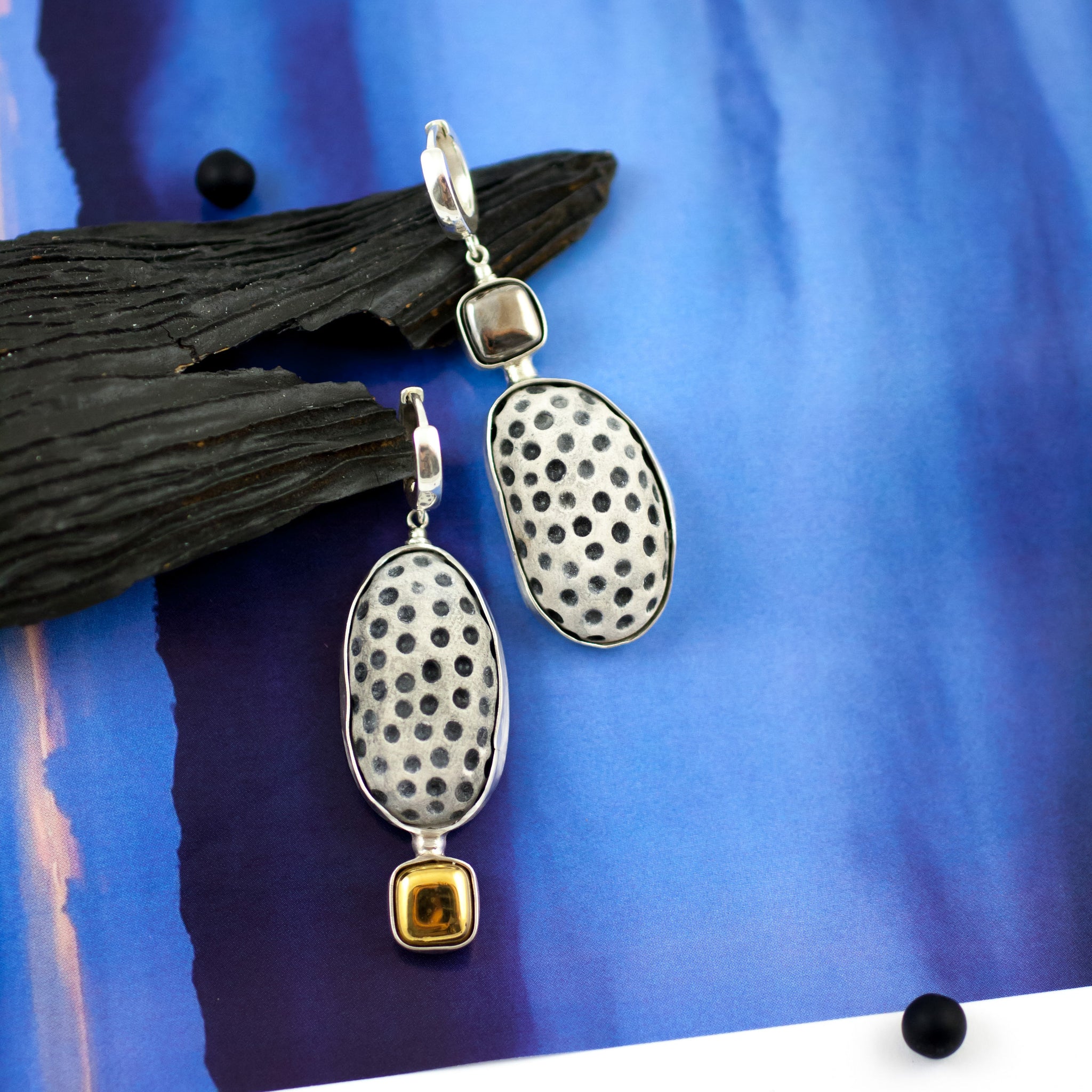 Gold and platinum plated asymmetrical earrings with black dots