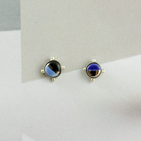 Mismatched silver stud earrings with blue ceramic details