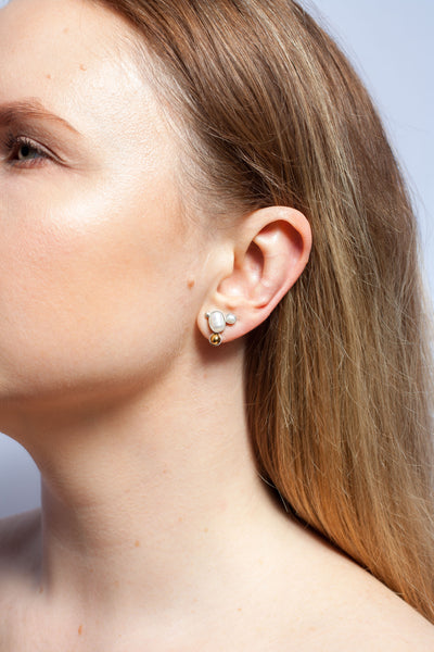 Mismatched silver stud earrings with golden ceramic details