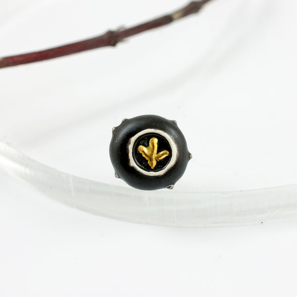 Black brooch with a golden flower