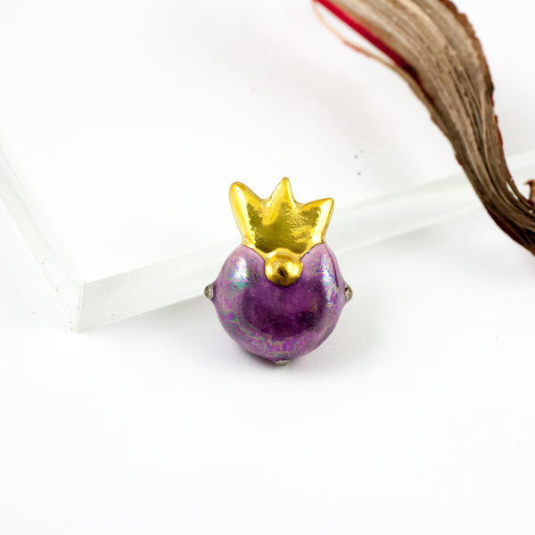 Purple brooch with a gold crown