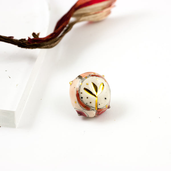 Pink color brooch with dots and a gold flower