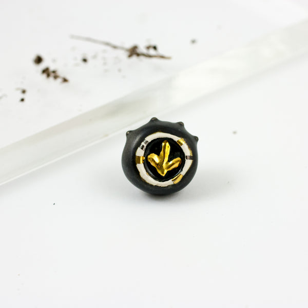 Black and white brooch with a gold flower