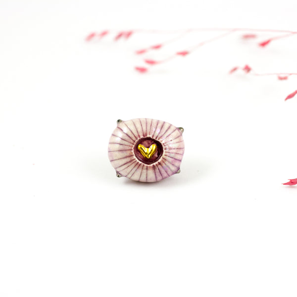 Pink brooch with a gold heart in the center
