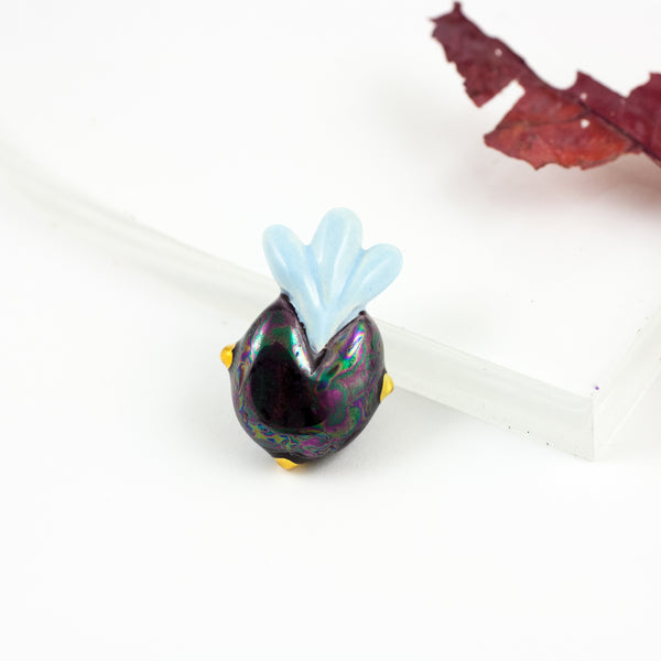 Aubergine color ceramic brooch with a baby blue crown