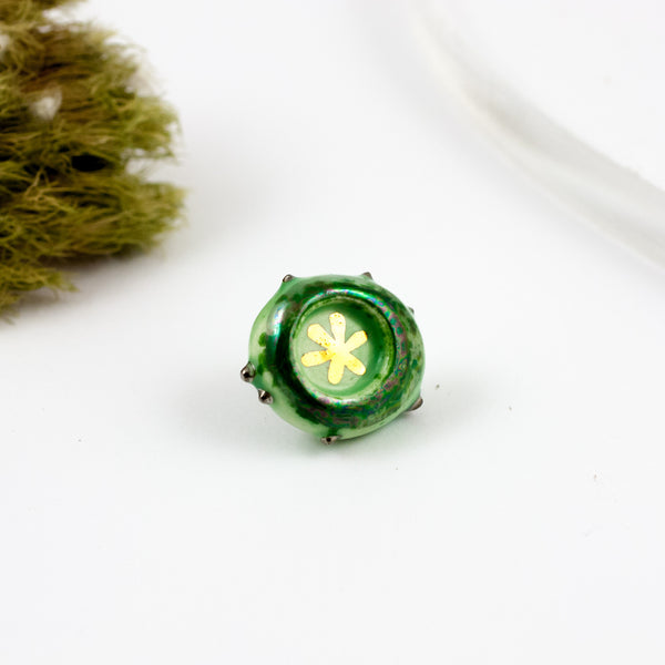 Two toned green ceramic brooch with a gold flower
