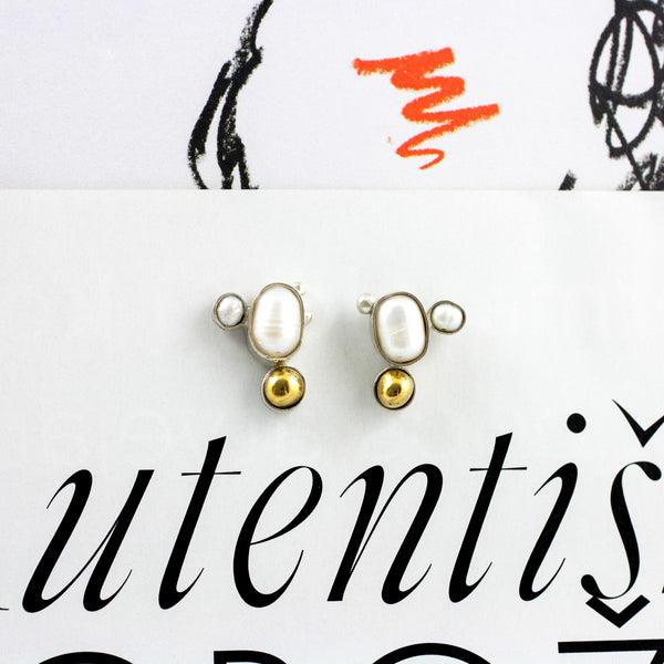 Mismatched silver stud earrings with golden ceramic details