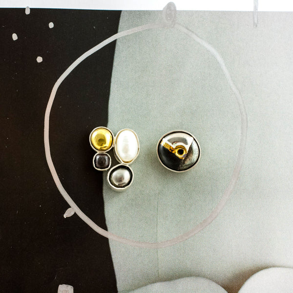 Mismatched silver stud earrings with a pearl and ceramic details