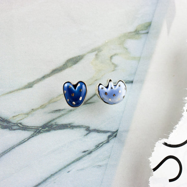 Blue mismatched silver earrings with a ceramic flower and a heart