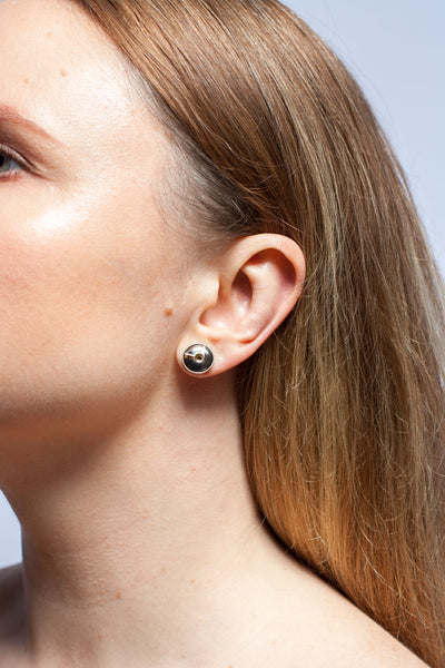 Mismatched silver stud earrings with a pearl and ceramic details