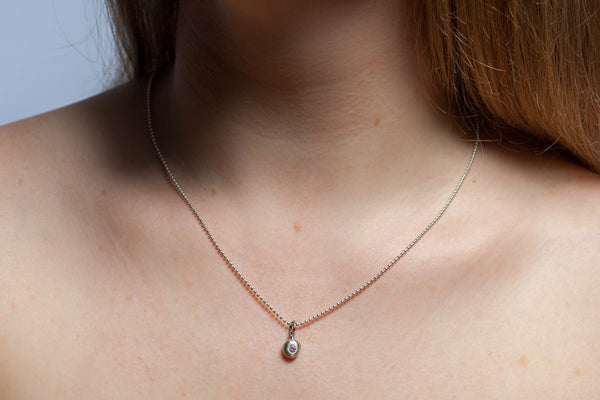 A tiny silver pendant with a pink zircon
