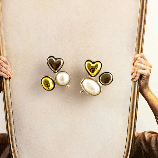 Mismatched silver stud earrings with freshwater pearls and ceramic hearts