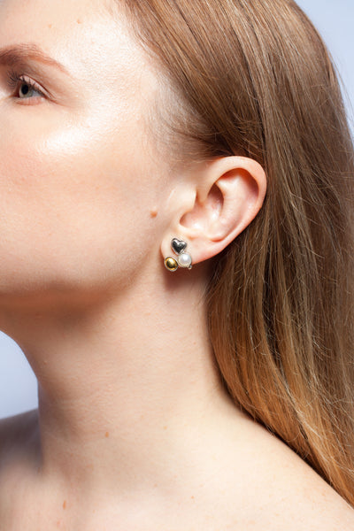 Mismatched silver stud earrings with freshwater pearls and ceramic hearts