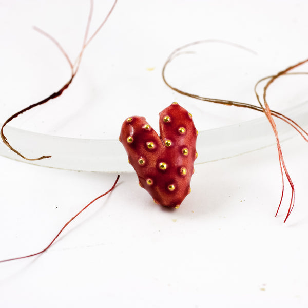 Dark red heart-shaped brooch with small gold dots