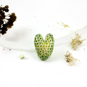 Žalia širdelės formos keramikos sagė su dėmelėmis
