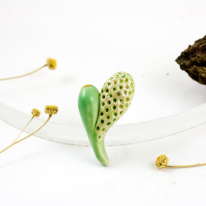 Zaļa ziedu pumpura formas broša ar plankumiem