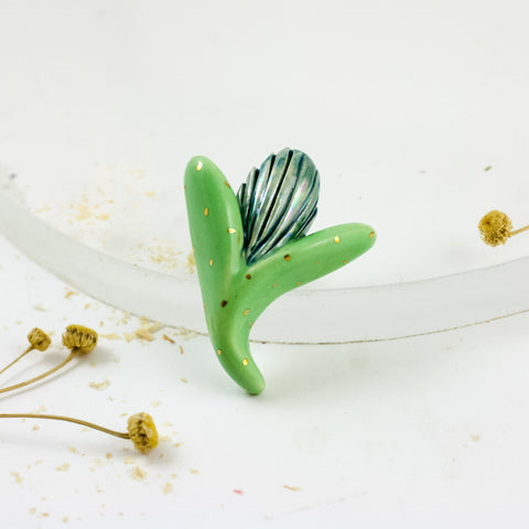 Spilgti zaļas un zilas krāsas organiska broša ar zelta spīduma detaļām