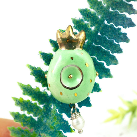 green ceramic brooch with crown and gold decor